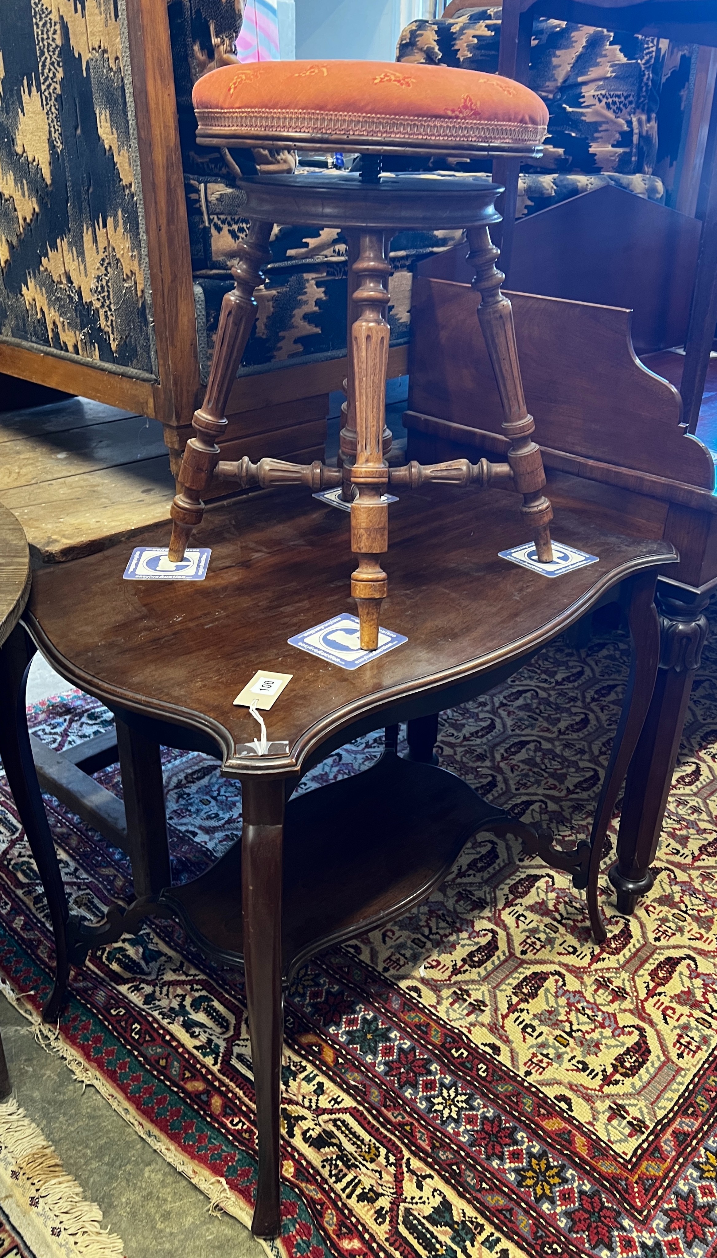 A late 19th century French walnut revolving adjustable piano stool and a Victorian mahogany centre table